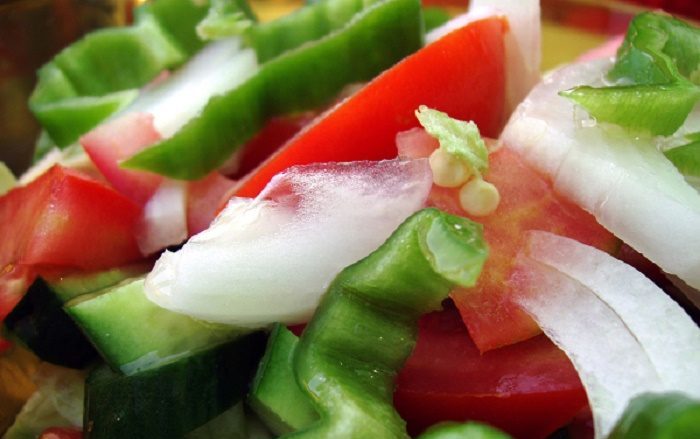 Imagen de una ensalada con tomates, lechuga, pimientos y cebolla