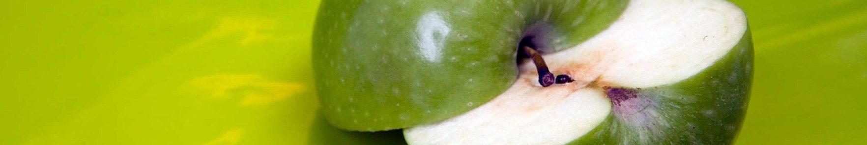 Imagen de manzana verde cortada a la mitad sobre fondo verde